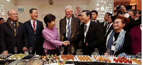 South Korean President Park Geun-hye (3rd from L) shakes hands with rapper Psy during a "Korea Night" banquet for foreign business leaders at a hotel in the Swiss ski resort town of Davos on Jan. 21, 2014. Park visited the town to attend the annual World Economic Forum after wrapping up her four-day state visit in Bern.(Yonhap) 