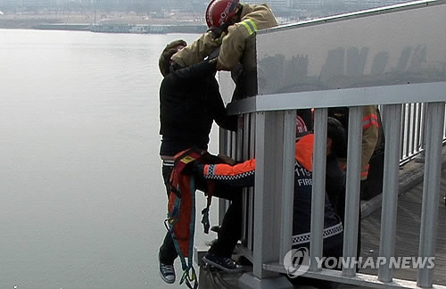 Южнокорейские спасатели пытаются предотвратить попытку самоубийства. Фото: Ренхап